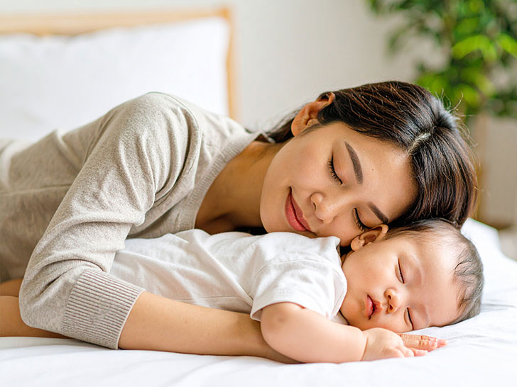 赤ちゃんと一緒に眠るお母さん