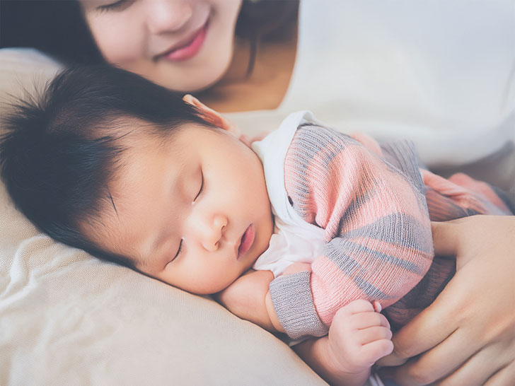 赤ちゃんと一緒に眠るお母さん