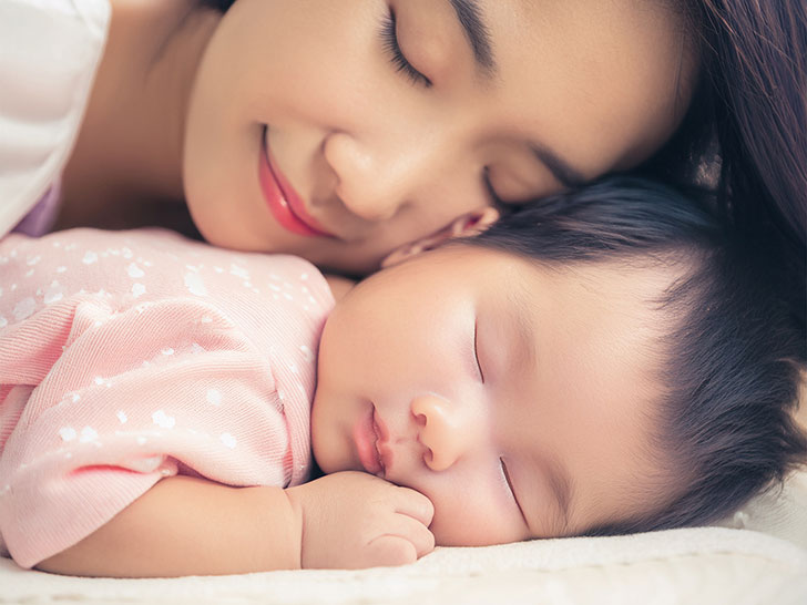 赤ちゃんと一緒に眠るお母さん