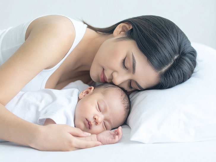 赤ちゃんと一緒に眠るお母さん