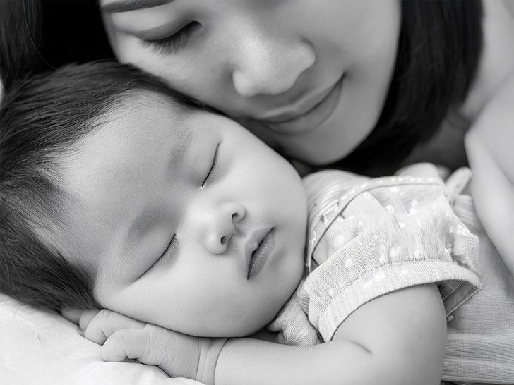 赤ちゃんと一緒に眠るお母さん