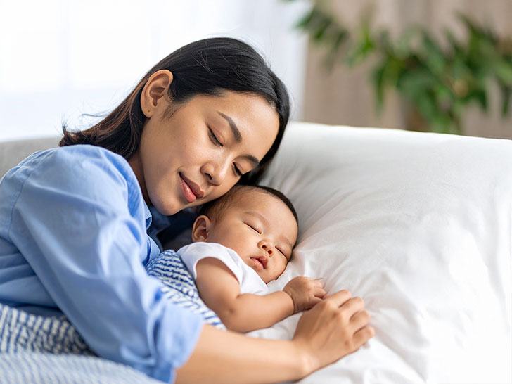 赤ちゃんと一緒に眠るお母さん