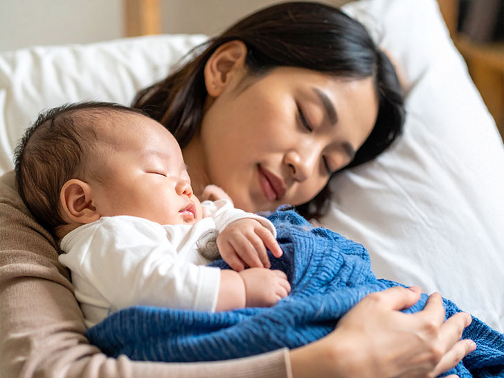赤ちゃんと一緒に眠るお母さん