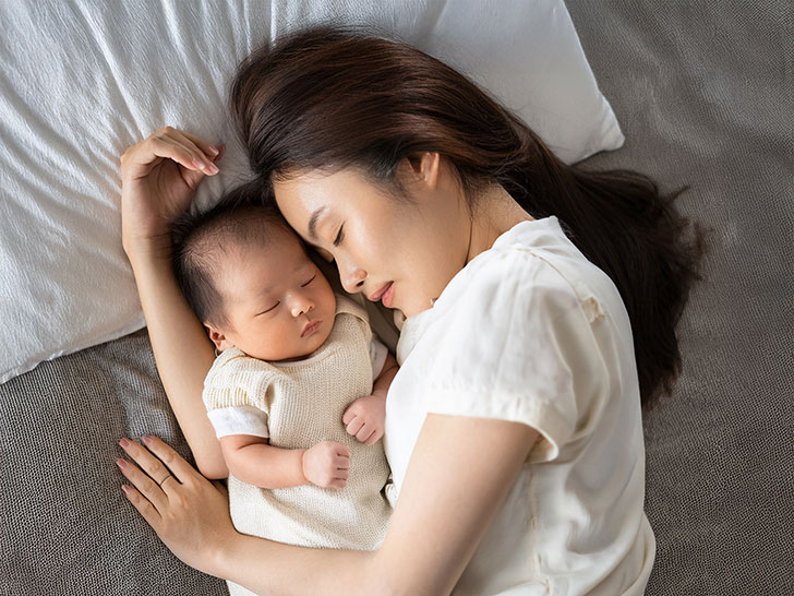赤ちゃんと一緒に眠るお母さん