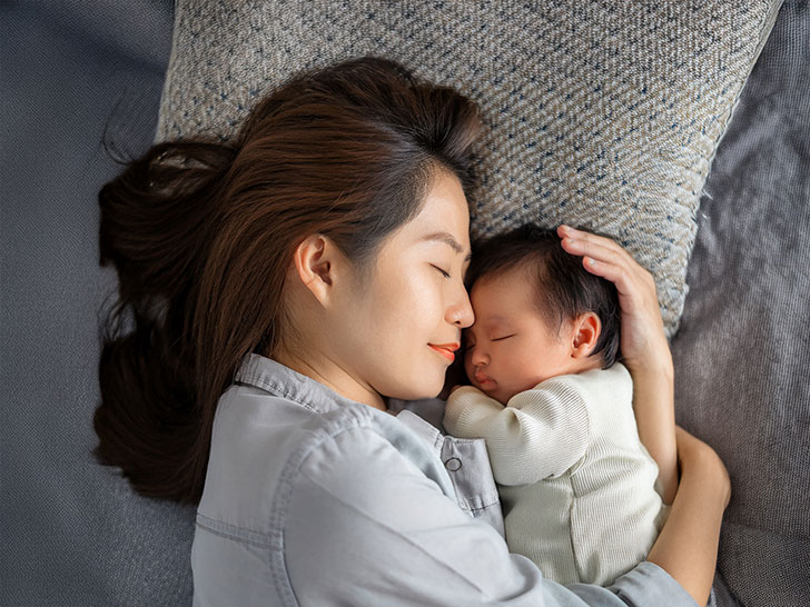 赤ちゃんと一緒に眠るお母さん