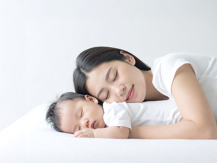 赤ちゃんと一緒に眠るお母さん