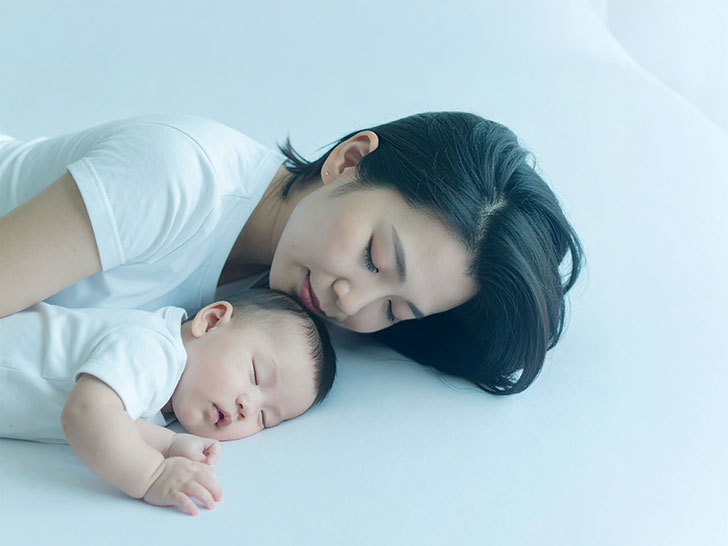 赤ちゃんと一緒に眠るお母さん