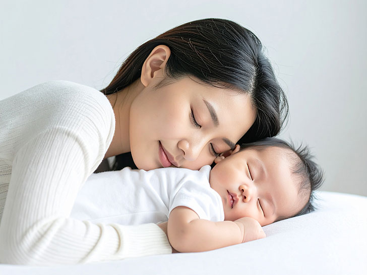 赤ちゃんと一緒に眠るお母さん