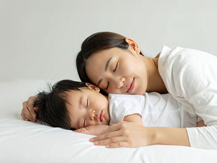 赤ちゃんと一緒に眠るお母さん
