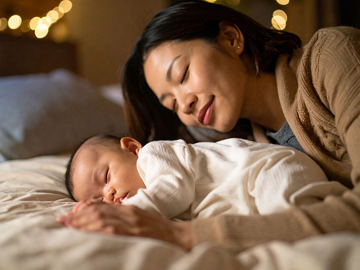 赤ちゃんと一緒に眠るお母さん