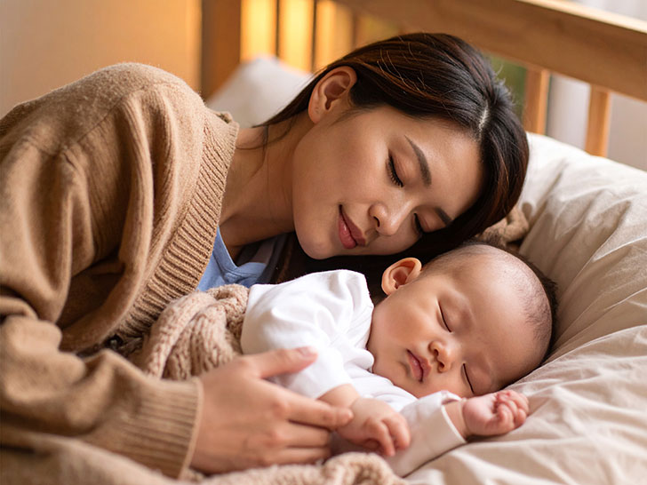 赤ちゃんと一緒に眠るお母さん
