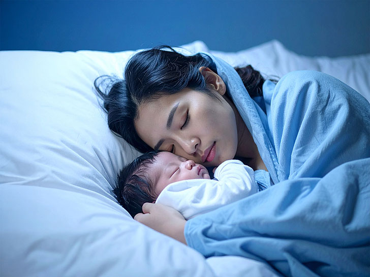 赤ちゃんと一緒に眠るお母さん