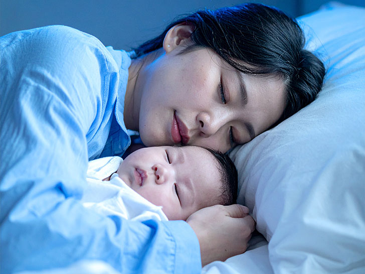 赤ちゃんと一緒に眠るお母さん