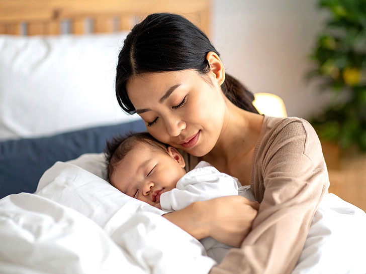 赤ちゃんと一緒に眠るお母さん