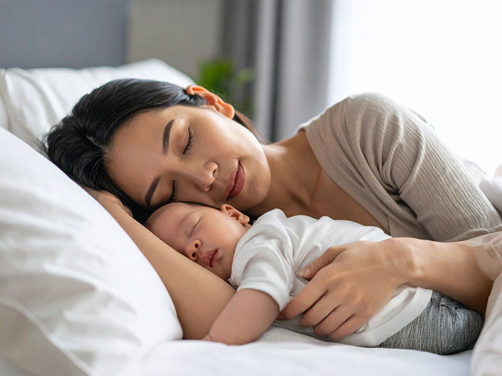 赤ちゃんと一緒に眠るお母さん