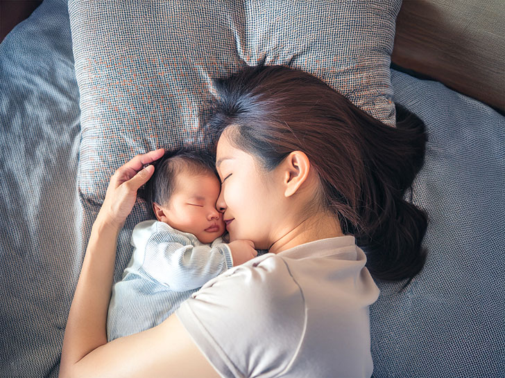 赤ちゃんと一緒に眠るお母さん