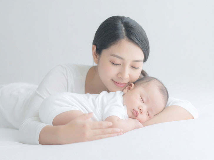 赤ちゃんと一緒に眠るお母さん