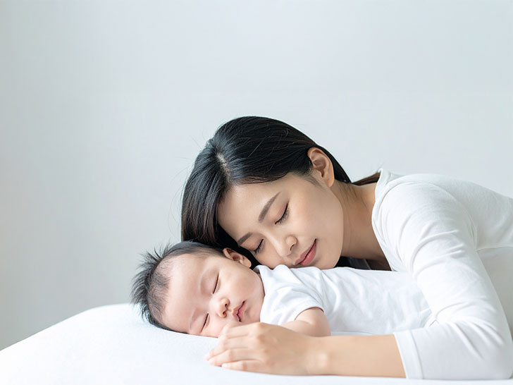 赤ちゃんと一緒に眠るお母さん