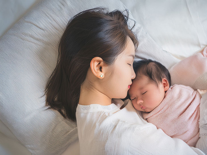 赤ちゃんと一緒に眠るお母さん