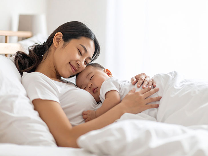 赤ちゃんと一緒に眠るお母さん