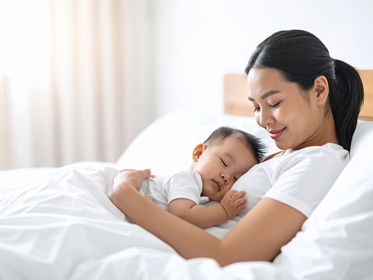 赤ちゃんと一緒に眠るお母さん
