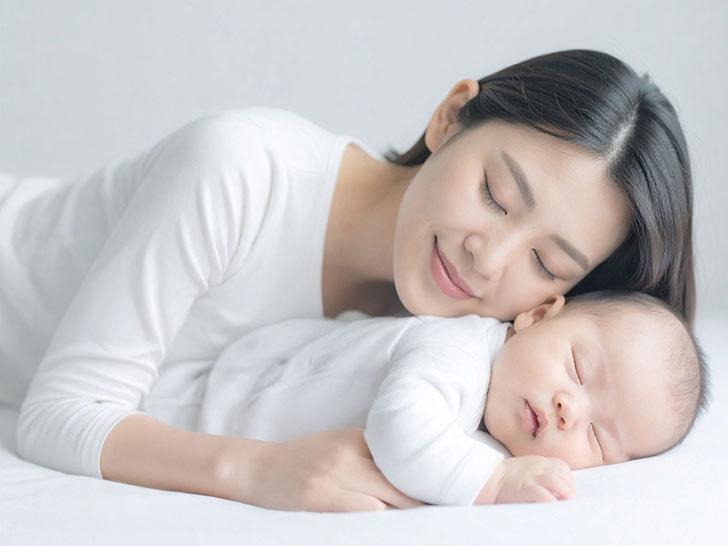 赤ちゃんと一緒に眠るお母さん