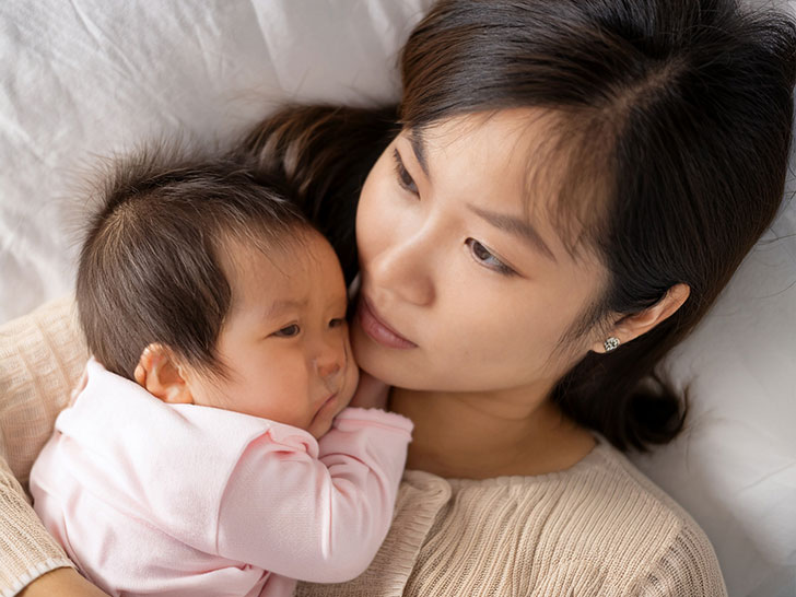 赤ちゃんと一緒に眠るお母さん