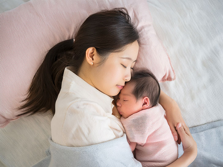 赤ちゃんと一緒に眠るお母さん