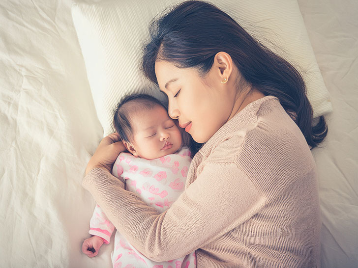 赤ちゃんと一緒に眠るお母さん