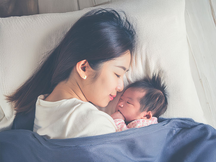赤ちゃんと一緒に眠るお母さん