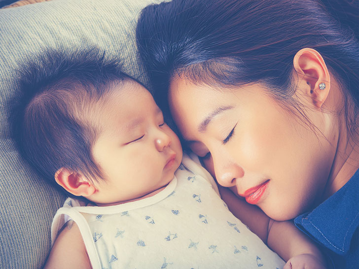 赤ちゃんと一緒に眠るお母さん