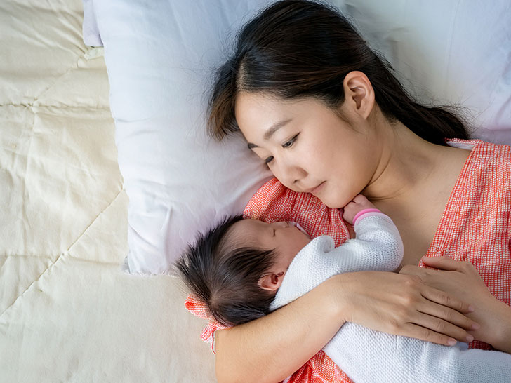 赤ちゃんと一緒に眠るお母さん
