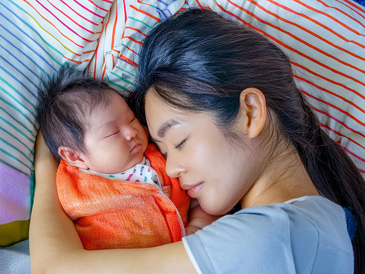 赤ちゃんと一緒に眠るお母さん