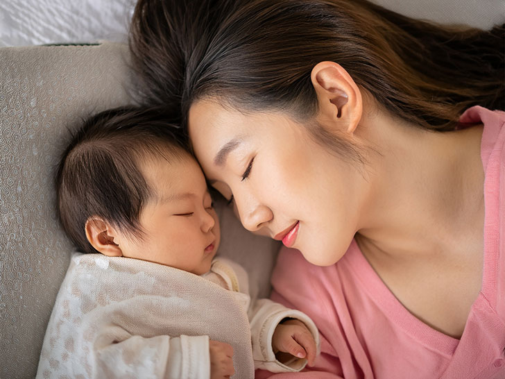 赤ちゃんと一緒に眠るお母さん