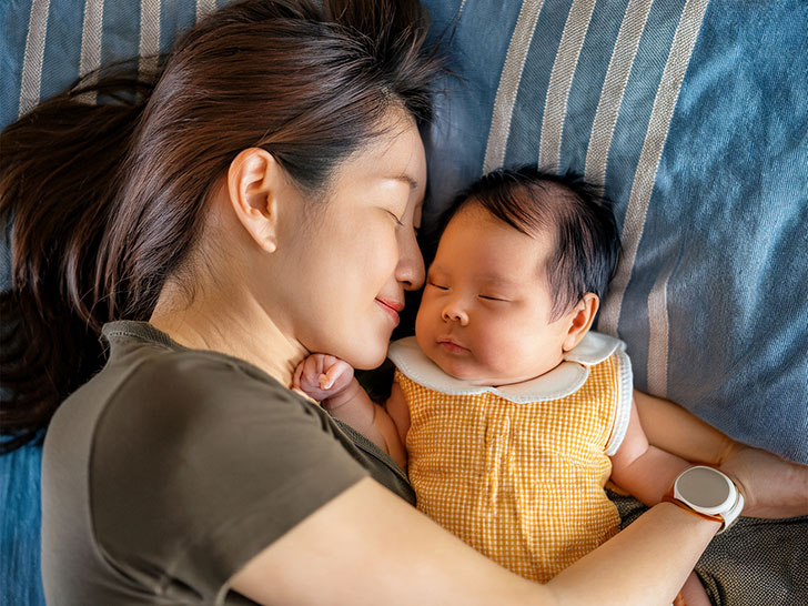赤ちゃんと一緒に眠るお母さん