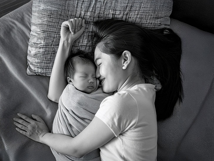 赤ちゃんと一緒に眠るお母さん