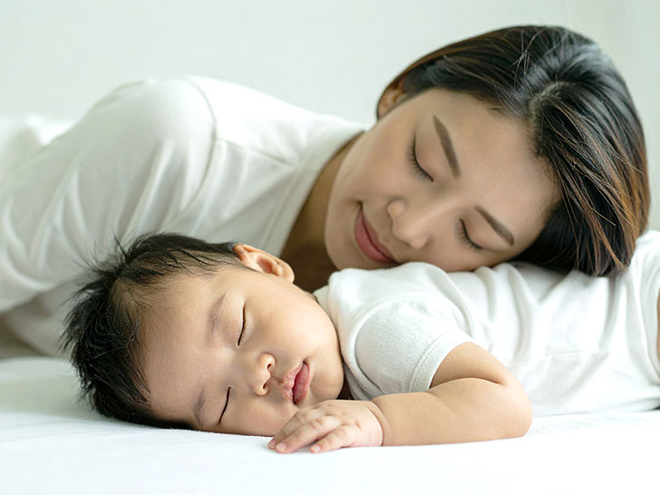 赤ちゃんと一緒に眠るお母さん