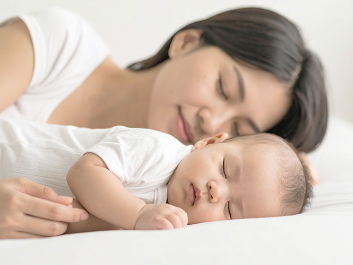 赤ちゃんと一緒に眠るお母さん