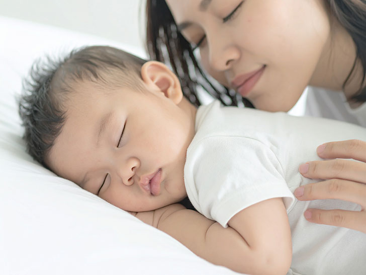 赤ちゃんと一緒に眠るお母さん