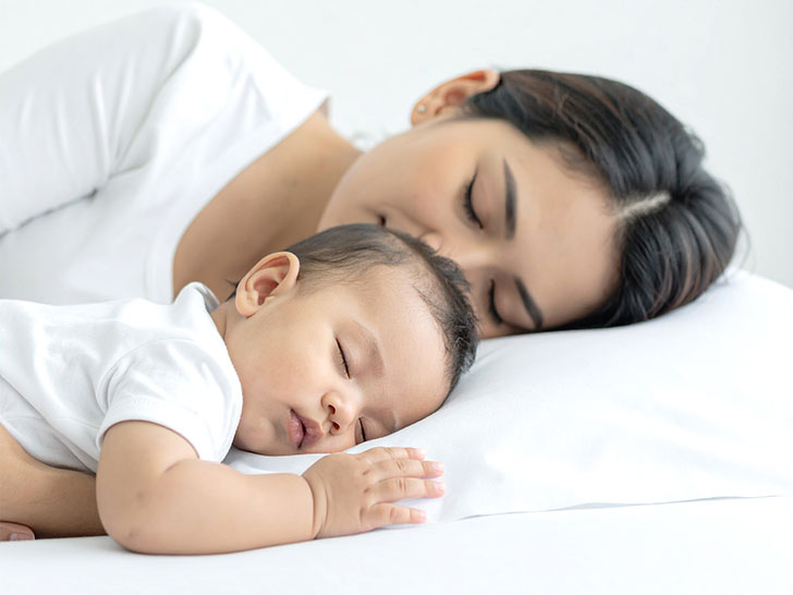 赤ちゃんと一緒に眠るお母さん