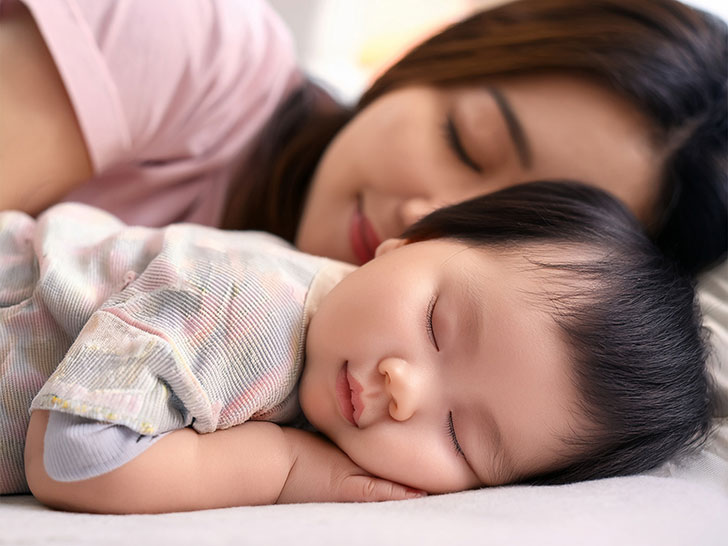 赤ちゃんと一緒に眠るお母さん