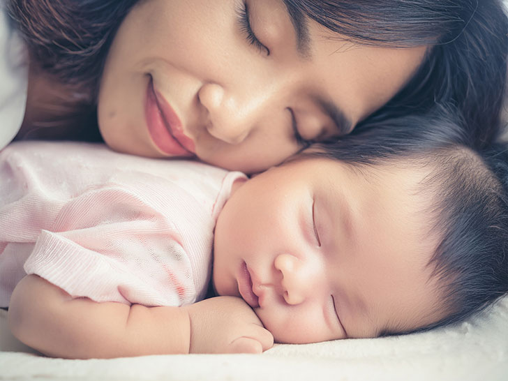 赤ちゃんと一緒に眠るお母さん
