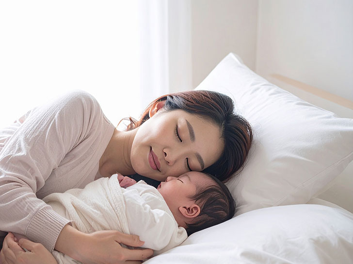 赤ちゃんと一緒に眠るお母さん
