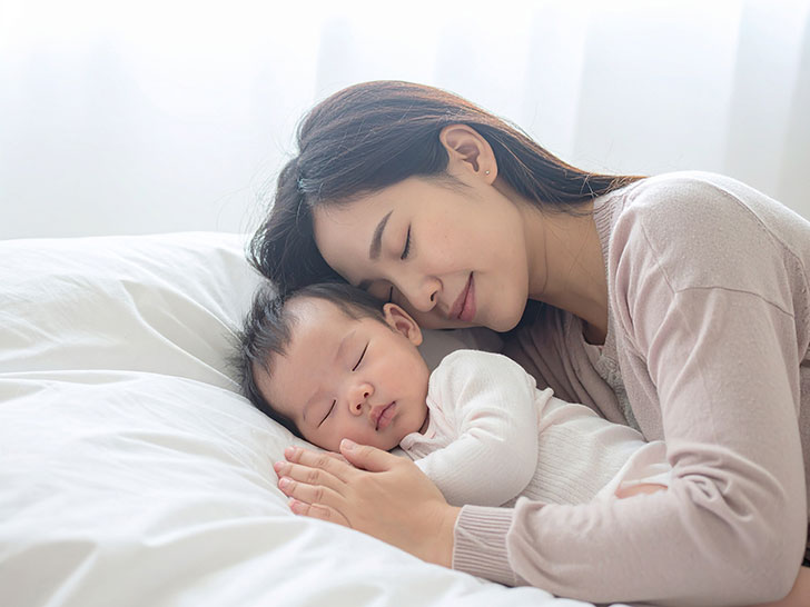赤ちゃんと一緒に眠るお母さん