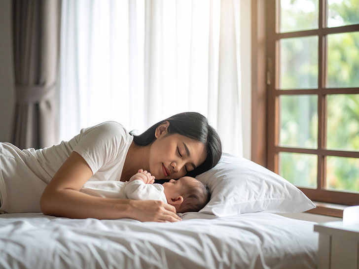 赤ちゃんと一緒に眠るお母さん