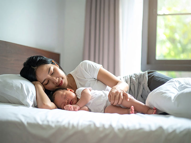 赤ちゃんと一緒に眠るお母さん