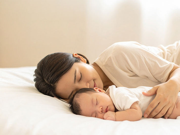 赤ちゃんと一緒に眠るお母さん