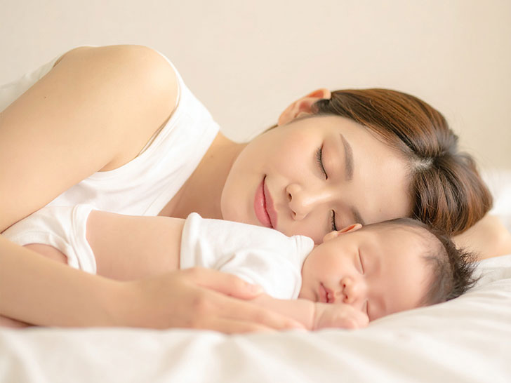 赤ちゃんと一緒に眠るお母さん