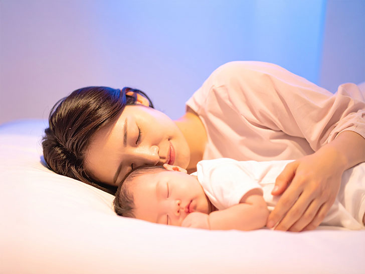 赤ちゃんと一緒に眠るお母さん