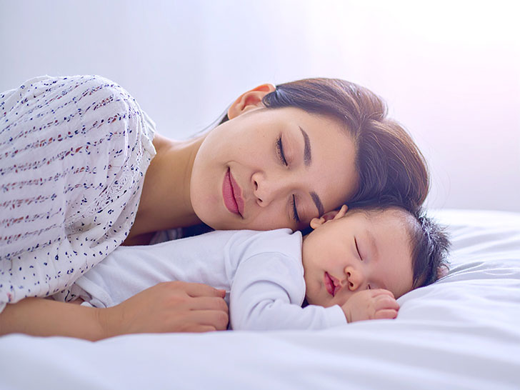 赤ちゃんと一緒に眠るお母さん